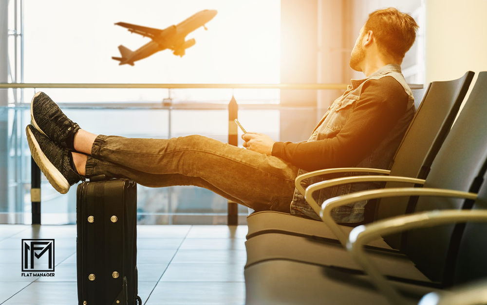 Guy waiting at the airport and looking at a plan that is just taking off